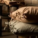 Rustic charm with handmade pillowcases on wooden stools, perfect for cozy interiors.